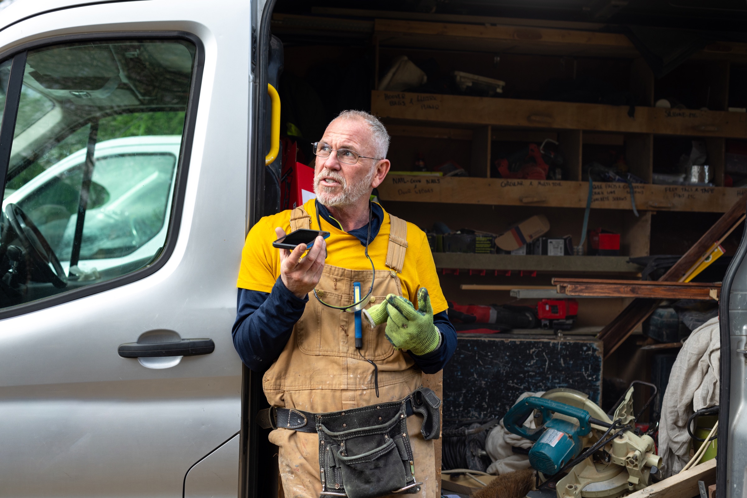UK tradesperson at the open back of a van packed with tools