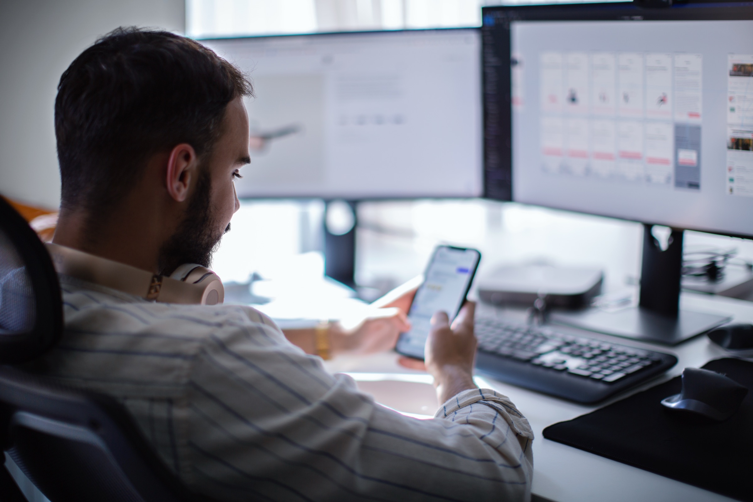 Person checking a website across a monitor and a phone